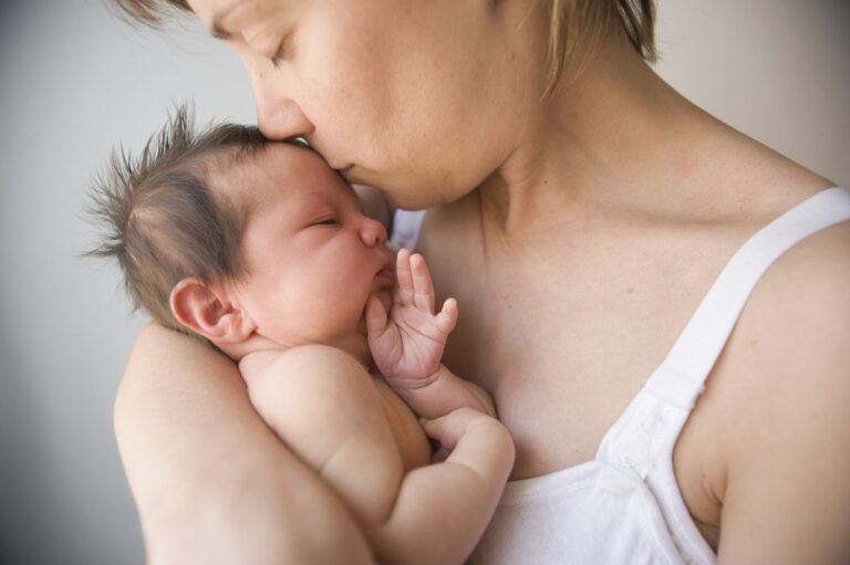 Mother kissing newborn
